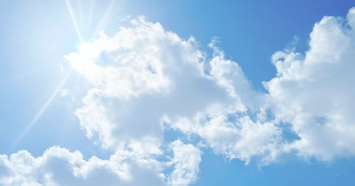 快晴の青空と白く光る雲の隙間から見える輝く日の光